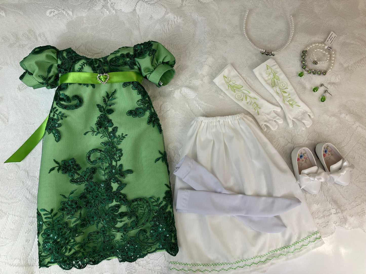 Green lace dress with matching accessories on a textured surface
