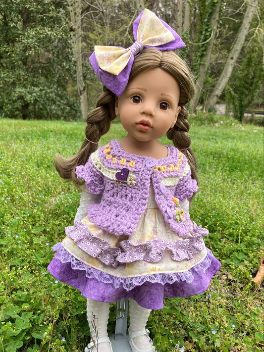 Doll in a purple dress with a large bow standing outdoors on grass